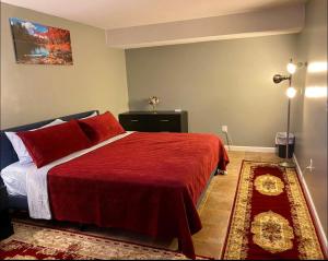 a bedroom with a bed with a red blanket and a rug at Van Gogh Guest Rm #7 • Van Gogh 7-Private BSMT Rm in single family home in Rosedale