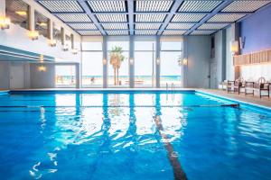 a large swimming pool with blue water at Renaissance Tel Aviv Hotel in Tel Aviv