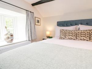 Old Farm Cottage في آمبيلسايد: غرفة نوم بسرير كبير ونافذة