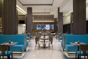 a restaurant with tables and chairs and a kitchen at Fairfield by Marriott Belitung in Tanjungpandan