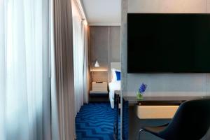 a hotel room with a bed and a flat screen tv at Renaissance Warsaw Airport Hotel in Warsaw