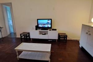 una sala de estar con TV en un armario blanco en Todo cerca en San Isidro en San Isidro