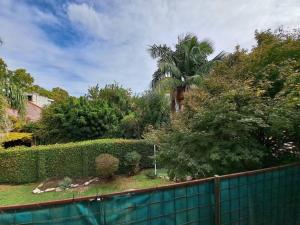 a garden with a fence and a palm tree at Todo cerca en San Isidro in San Isidro