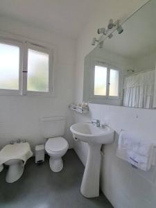 a white bathroom with a toilet and a sink at Todo cerca en San Isidro in San Isidro