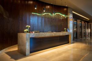 a lobby with a reception counter with a chandelier at Renaissance Atyrau Hotel in Atyrau