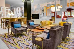 een lobby met stoelen en een tafel en een bank bij Sheraton McKinney in McKinney