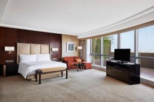 um quarto de hotel com uma cama e uma televisão em JW Marriott Hotel Beijing Central em Pequim