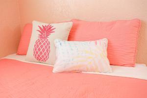 een roze bed met 2 kussens en een ananaskussen bij License to Chill - Heated Pool, Indian Rocks Beach, Play Room in Largo