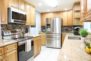 a kitchen with wooden cabinets and stainless steel appliances at License to Chill - Heated Pool, Indian Rocks Beach, Play Room in Largo