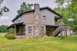 una casa vieja con una chimenea de piedra en un campo en Pet-Friendly Hollywood Cabin Apartment Near Lake!, 