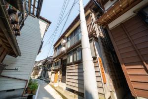系魚川市的住宿－えのきや，街道旁有白色柱子的建筑