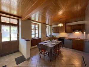 a large kitchen with a table in the middle at Gîte Laprugne, 3 pièces, 6 personnes - FR-1-489-448 in Laprugne