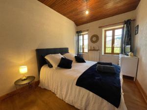 a bedroom with a bed and a lamp and a window at Gîte Laprugne, 3 pièces, 6 personnes - FR-1-489-448 in Laprugne