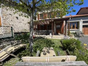 a house with a bench and a tree in the yard at Gîte Laprugne, 3 pièces, 6 personnes - FR-1-489-448 in Laprugne