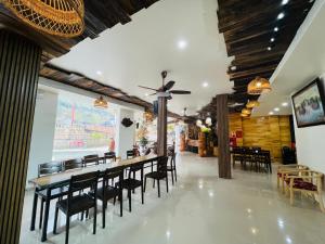a dining room with a long table and chairs at Heaven Hill Hotel & Hot Spring in Cham Ta Lao