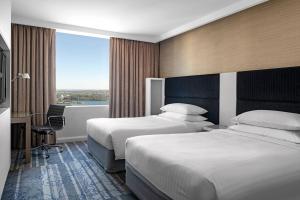 a hotel room with two beds and a window at Sydney Harbour Marriott Hotel at Circular Quay in Sydney
