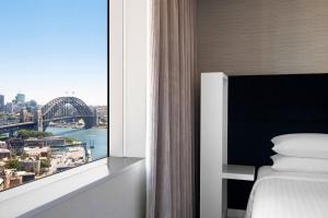 a bedroom with a window with a view of a bridge at Sydney Harbour Marriott Hotel at Circular Quay in Sydney