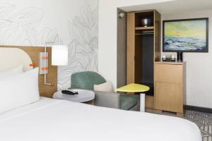 a hotel room with a bed and a chair and a television at SpringHill Suites by Marriott New York Manhattan Chelsea in New York