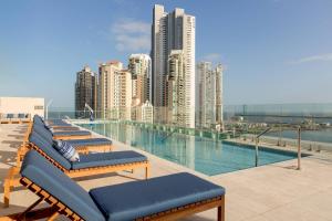 a row of lounge chairs next to a swimming pool at Residence Inn by Marriott Panama City in Panama City