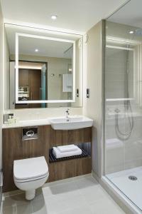 La salle de bains est pourvue de toilettes, d'un lavabo et d'une douche. dans l'établissement Courtyard by Marriott Oxford South, à Abingdon