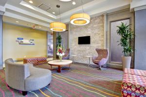 a lobby with chairs and a table and a tv at Fairfield Inn & Suites by Marriott Guelph in Guelph