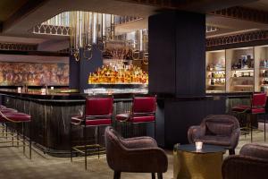 a bar in a hotel with chairs and a bar counter at The St. Regis Jakarta in Jakarta