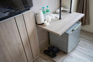 Il comprend une petite cuisine avec un comptoir en bois et un réfrigérateur. dans l'établissement 天璽商務飯店 Cullinan Hotel, à Hualien