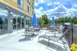 a patio with tables and chairs with blue umbrellas at Fairfield Inn & Suites by Marriott Greenville in Greenville
