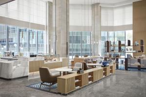 een lobby met stoelen en tafels en grote ramen bij Sheraton Fuqing Hotel in Fuqing