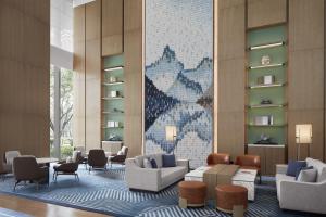 a lobby with couches and chairs and a mosaic wall at Sheraton Fuqing Hotel in Fuqing