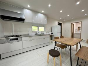 a large kitchen with a wooden table and a dining room at SHIRAHAMA condominium D-100 in Kanayama