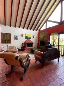 een woonkamer met lederen meubels en een open haard bij El paraíso in Paipa