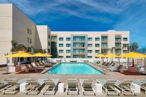 uma piscina com cadeiras e guarda-sóis em frente a um hotel em Residence Inn by Marriott at Anaheim Resort/Convention Center em Anaheim