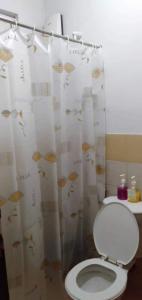 a bathroom with a toilet and a shower curtain with fish on it at Lemon Transient House in Angeles