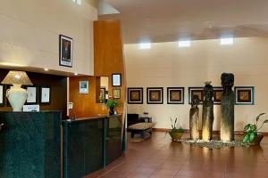 eine Lobby mit zwei Statuen in der Mitte eines Gebäudes in der Unterkunft Protea Hotel by Marriott Ondangwa in Ondangwa