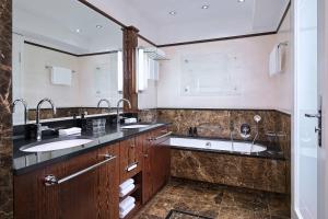 a bathroom with two sinks and a large mirror at Hotel Elephant Weimar, Autograph Collection in Weimar