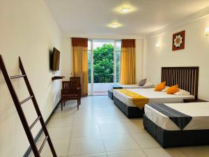 a hotel room with two beds and a balcony at Kandy Hub Guest House in Kandy
