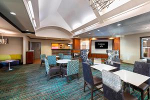a dining room with tables and chairs and a flat screen tv at Residence Inn by Marriott Lakeland in Lakeland