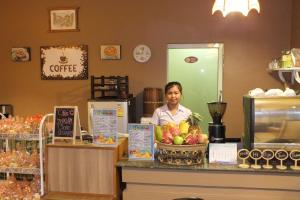 een vrouw die achter een toonbank in een koffiehuis staat bij Avalon Residence in Savannakhet
