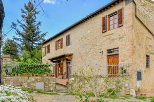 een oud stenen huis met een stenen muur bij Appartamento con vista panoramica in Chianti in San Donnino