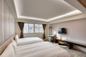 Habitación de hotel con 2 camas y TV en 天璽商務飯店 Cullinan Hotel en Hualien