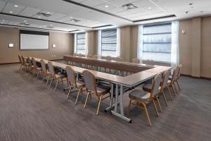 Four Points by Sheraton Edmonton West في إيدمونتون: قاعة اجتماعات كبيرة مع طاولة وكراسي طويلة