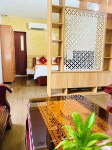 Quảng TrịにあるKhách sạn Khánh Phươngのベッドとガラスのテーブルが備わる客室です。