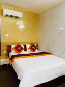 Quảng Trị的住宿－Khách sạn Khánh Phương，一间卧室配有一张带红色枕头的床