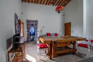 een eetkamer met een houten tafel en rode stoelen bij Appartamento con vista panoramica in Chianti in San Donnino
