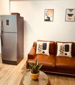 a living room with a brown couch and a refrigerator at Lagom studio 18 - đẹp và yên bình, kế bên dinh độc lâp, nhà thờ Đức Bà, đường Nguyễn Du, phường Bến Nghé, Quận 1 in Ho Chi Minh City