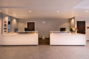 an office with two reception desks and a clock on the wall at Residence Inn by Marriott Palo Alto Menlo Park in Menlo Park
