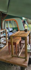 a tent with a wooden table and a bench with a tent at Jungle Glamping Tent in Maluk