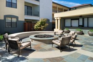 a patio with chairs and a fire pit in front of a building at Residence Inn by Marriott Palo Alto Menlo Park in Menlo Park