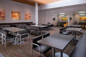 a dining room with tables and chairs and paintings at Residence Inn by Marriott Palo Alto Menlo Park in Menlo Park